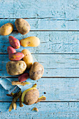Various potatoes on a pale blue wooden background