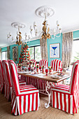 Chairs with red-and-white striped loose covers around festively set table