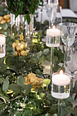 Festliche Kerzenständer und Eukalyptuszweige auf Weihnachtstisch