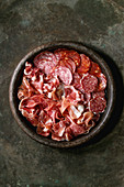 Antipasto meat platter assorti of sliced jamon, salami, chorizo sausage in terracotta tray