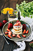 Soft pancakes with fresh strawberries on ceramic plate