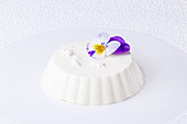 Panna cotta decorated with edible violet flower