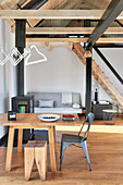 Offener Wohnraum in umgebauter Scheune mit Holztreppe zur Galerie