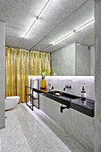 Grey, modern bathroom with indirect lighting on mirrored wall