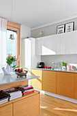 Bright fitted kitchen with island counter in open-plan interior