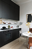 Dining area next to kitchen counter with black cabinets