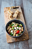 Wholegrain pasta salad with tomato, feta and cucumber, served with cereal bars