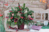 Advent bouquet made of evergreen branches with ornamental apples and straw snowflakes