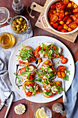 Toasted bread with baked tomatoes, mozzarella and arugula