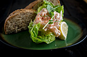 Shrimpscocktail auf Salatblatt mit Brot