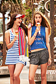 Two girls eating ice cream on a beach