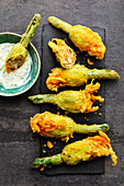 Baked zucchini flowers with pretzel and cheese filling and a dip