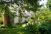 Idyllic cottage with chimney in summery garden