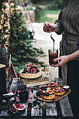 A table laid in a garden with fig tarts and coffee