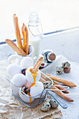 Zutaten für Frühstück: gekochtes Ei, Brotsticks und Milch