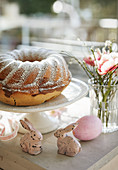 A Bundt cake decorated with eggs, bunnies and flowers for Easter