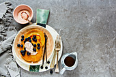 Homemade vanilla pancakes with maple syrup, fresh blueberries and yogurt