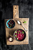 Beetroot soup in bowls on a rustic wooden board
