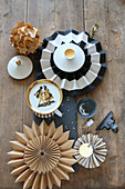 Festive arrangement of vintage plate, paper flowers, star and grey candles on slate board decorating table