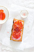Rectangular puff pastry tartlet with pink strawberry mousse and blood orange slices