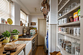 Schmale Küche im Landhausstil mit halbhoher Wandverkleidung