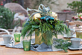 Weihnachtsstrauß in goldener Vase als Tischdekoration