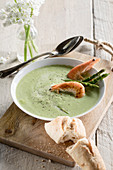 Green asparagus soup with prawns and baguette