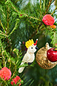 Kakadu, goldene Kugel, Pompons und Äpfelchen als Christbaumschmuck