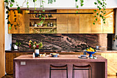 Küche mit goldfarbenen Fronten und mauvefarbener Frühstücksbar