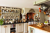 Dresser, AGA cooker and island counter in English country-house kitchen