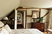 Schlafzimmer in englischem Landhaus mit niedriger Decke und Fachwerkbalken