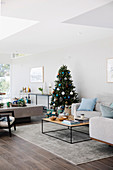 Bright living room decorated for Christmas with sofa and coffee table