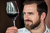Mann mit Bart testet Rotwein