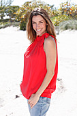 A brunette woman outside wearing a red top