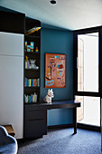 Fitted wardrobe and desk in the children's room with a blue wall