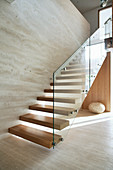 Wooden stairs with glass railings in an ecological architect's house