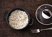 Boiled rice being fluffed up with a fork