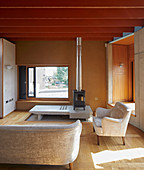 Log-burner on platform in experimental architect-designed house