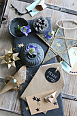 Handcrafted Christmas decorations made from brown paper and gentian in small pewter dish and vase