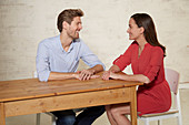 Mann und Frau sitzen am Tisch