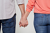 Frau und Mann gehen Hand in Hand (Körpersprache: 'Starke Verbundenheit')