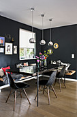 Dining table, classic chairs and modern wooden corner bench in black dining room