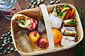 Picknick basket with Vietnameese banh mi-sandwich, ray bread with fillings and a wrap with bean stirring