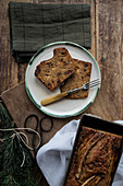 Healthy banana bread in container and slices in a plate on chopping board