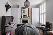 Open fireplace in classic bedroom in shades of grey