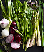 An arrangement of vegetables with asparagus, onions, garlic and herbs