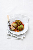 Savoy cabbage rolls with pork and mortadella filling on tomato sauce