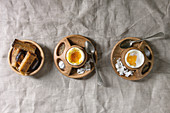 Breakfast with soft boiled eggs, served in wooden egg cup with salt, pepper and toasted bread