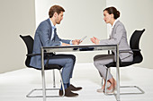 A man and a woman having a business conversation with him looking at a phone