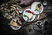 Cheese cake pieces served on plate with berry on dark wooden table